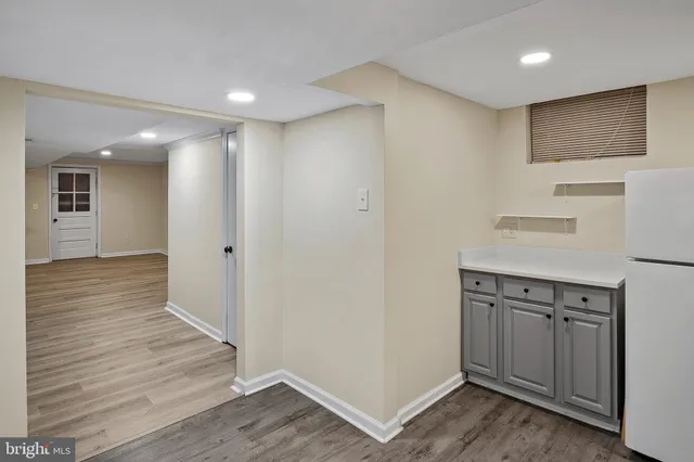 a view of a kitchen with refrigerator and wooden floor