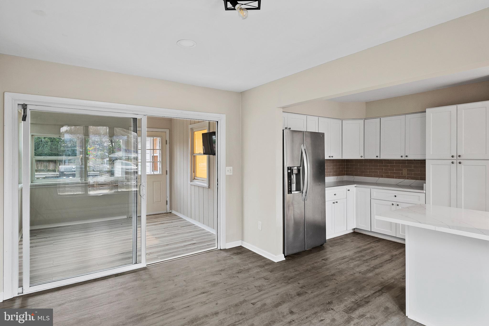 8084 Clark Station Road Severn, MD 21144 - Photo 9 of 36 a kitchen with granite countertop a refrigerator and a stove top oven