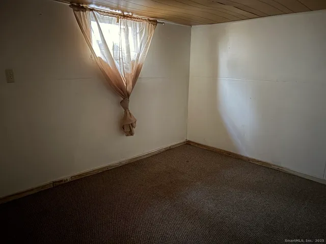 a view of a small space with wooden floor and a window