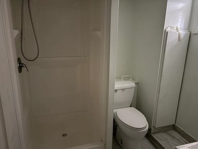 a bathroom with a toilet and a shower