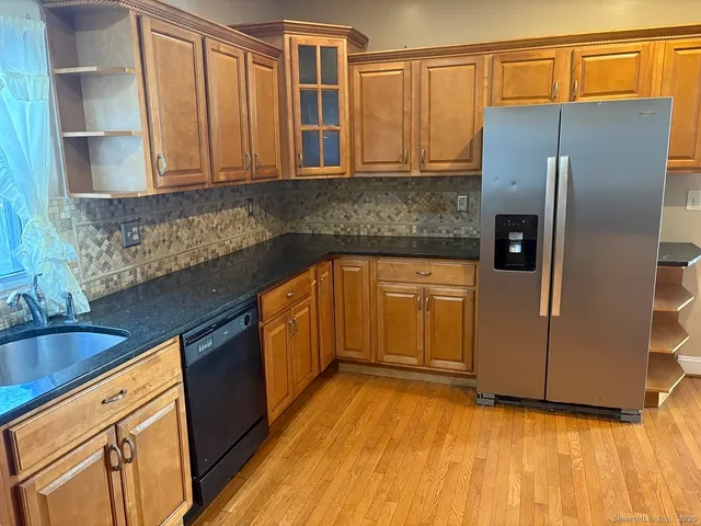 a kitchen with stainless steel appliances granite countertop a refrigerator and a sink