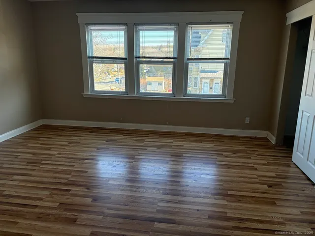 wooden floor in an empty room with a window