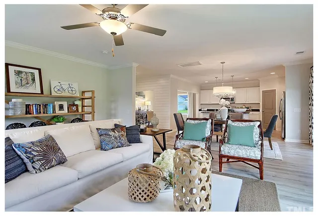 a living room with furniture and a dining table with wooden floor