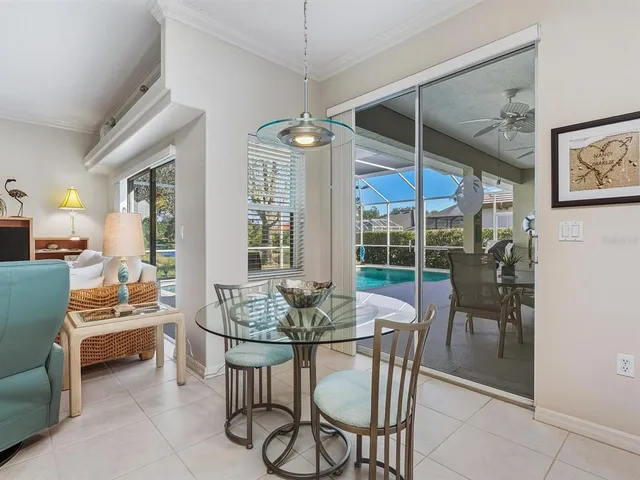a dining room with furniture a chandelier and glass door