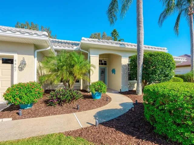 a view of a white house with potted plants