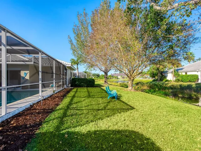 a view of backyard with wooden fence and large trees