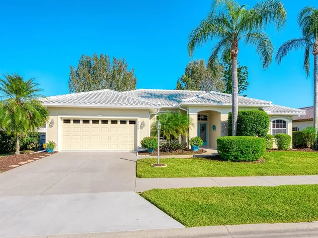 a view of a house with a yard and potted plants