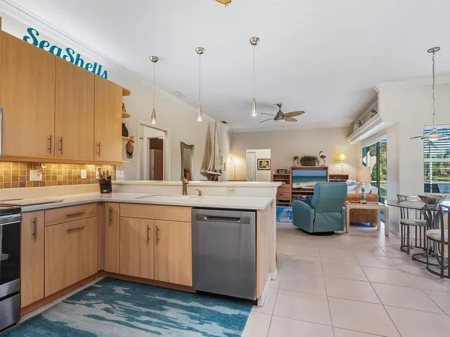 a large kitchen with cabinets a sink a counter space and stainless steel appliances