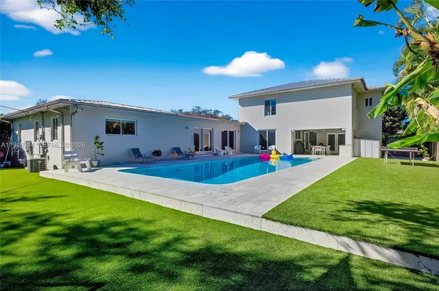 a view of an house with backyard and a tree