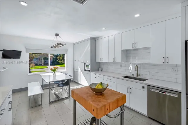a kitchen with a stove a sink a counter space and a dining table