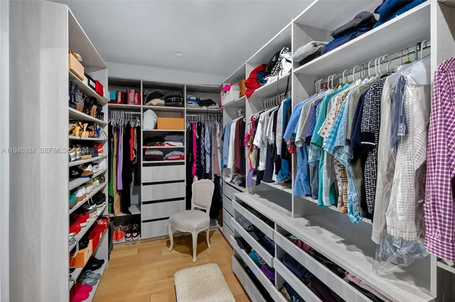 a view of walk in closet with clothes and shoes