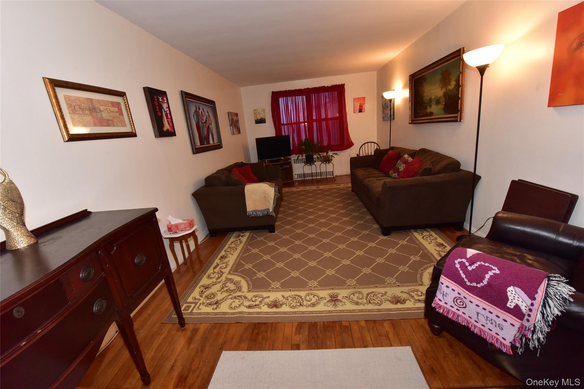 86-70 Francis Lewis Boulevard, Unit A46 Queens, NY 11423 - Photo 3 of 12 a living room with furniture and a flat screen tv