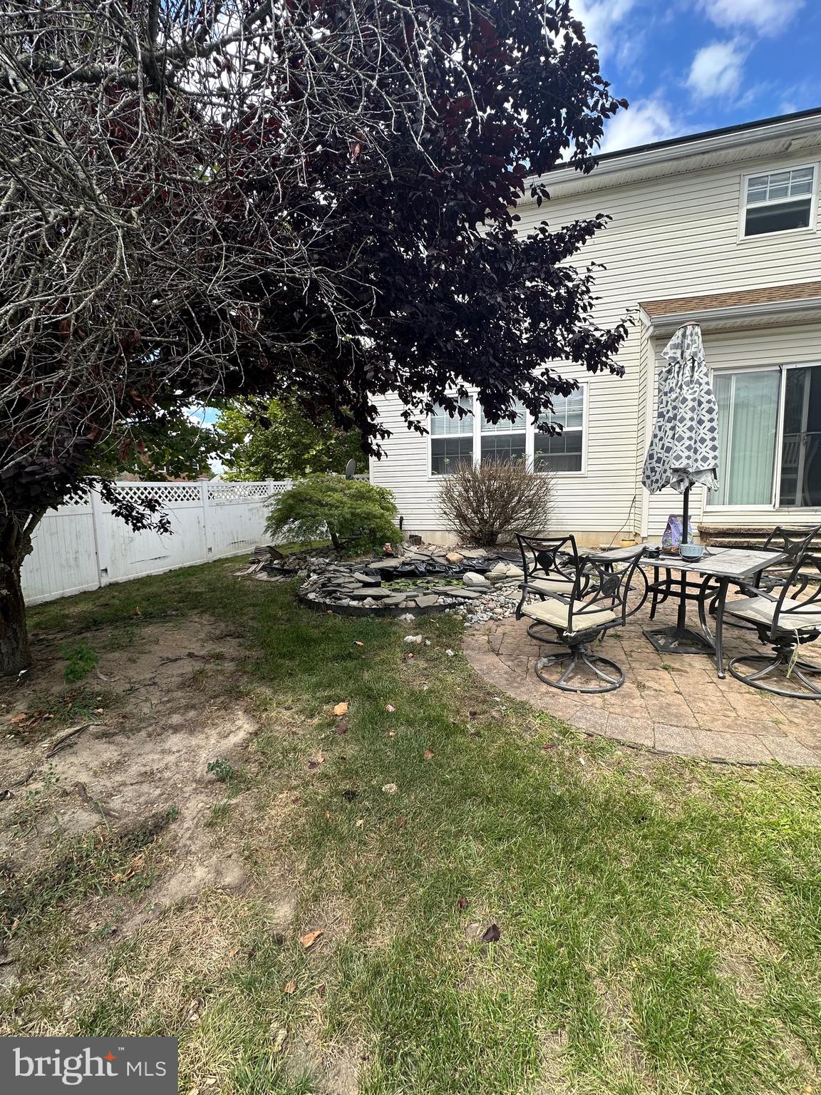 109 Harmony Cir Road Sicklerville, NJ 08081 - Photo 24 of 118 a view of a patio with table and chairs under an umbrella