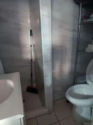 a white toilet sitting next to a shower