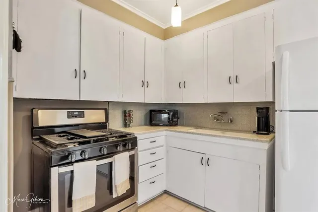 a kitchen with appliances a sink and cabinets