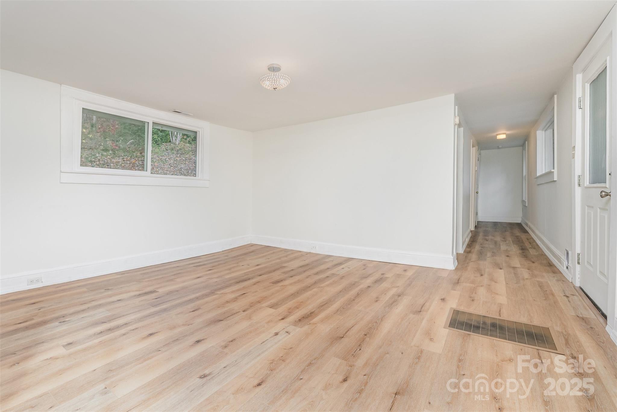 243 Boys Camp Road Black Mountain, NC 28711 - Photo 7 of 21 an empty room with wooden floor and windows
