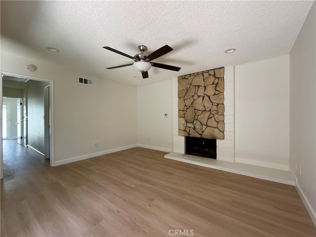 6441 St Paul Circle, Unit B Huntington Beach, CA 92647 - Photo 2 of 8 an empty room with wooden floor a ceiling fan and windows