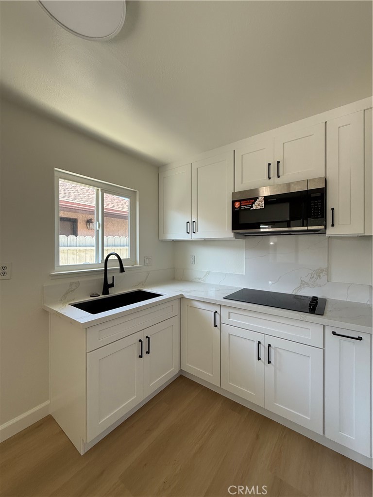 6441 St Paul Circle, Unit B Huntington Beach, CA 92647 - Photo 3 of 8 a kitchen with stainless steel appliances granite countertop a sink stove and cabinets