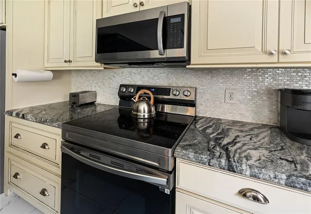 a kitchen with stainless steel appliances granite countertop a sink a refrigerator and a wooden floors