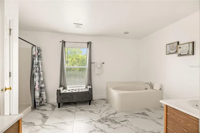 a view of a white house with a big yard and potted plants