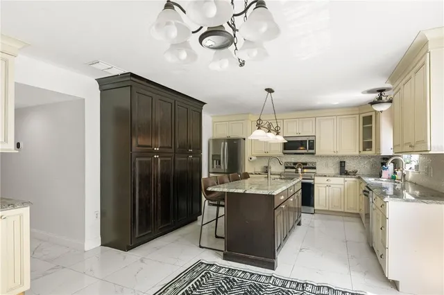 a kitchen with stainless steel appliances granite countertop a sink stove and cabinets