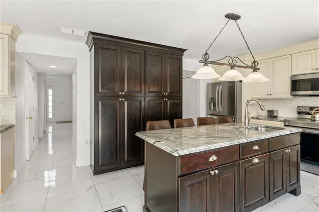 a kitchen with granite countertop a sink stainless steel appliances and cabinets