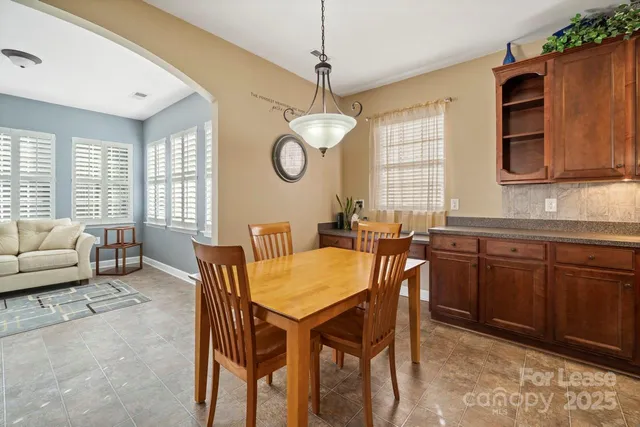 a kitchen with a table chairs sink and cabinets