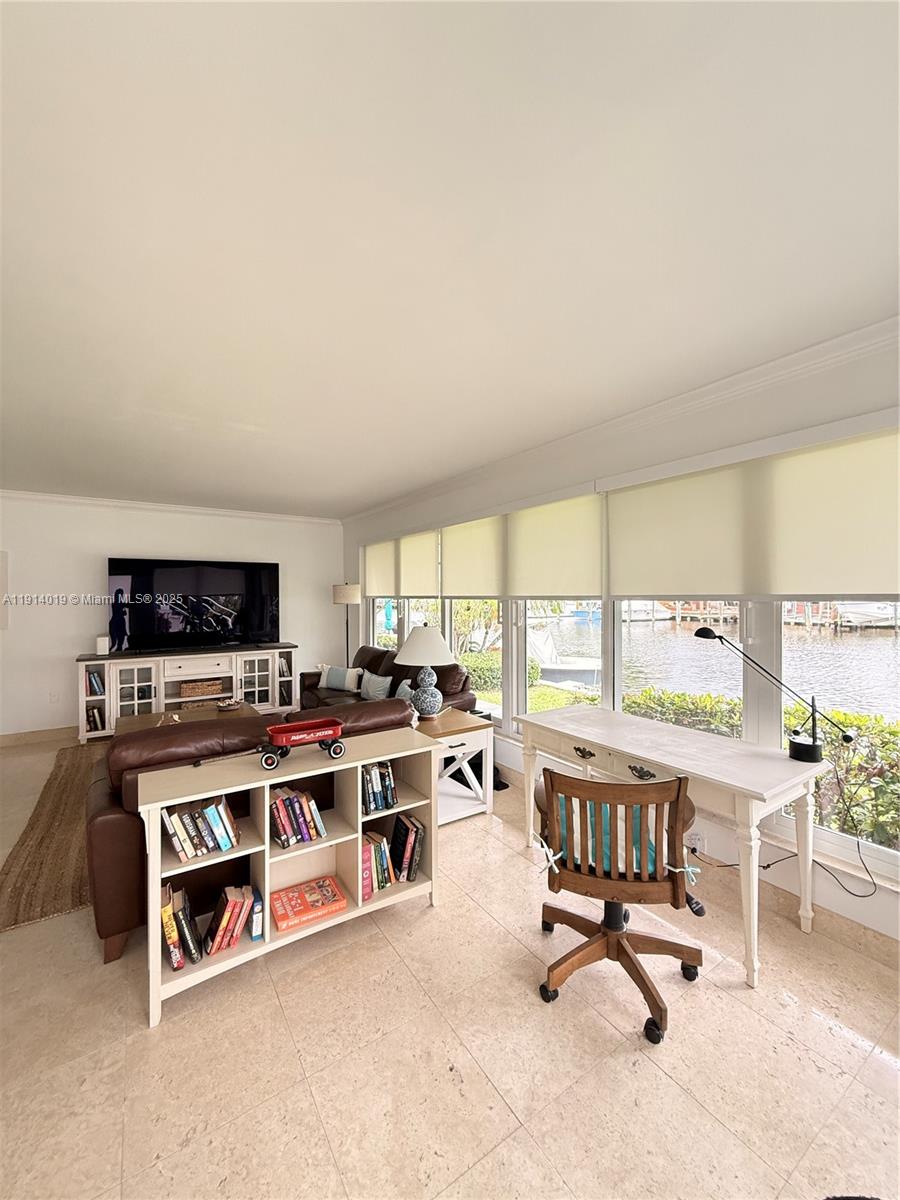 180 Isle Of Venice Drive, Unit 100 Fort Lauderdale, FL 33301 - Photo 4 of 16 a living room with furniture a flat screen tv and a fireplace