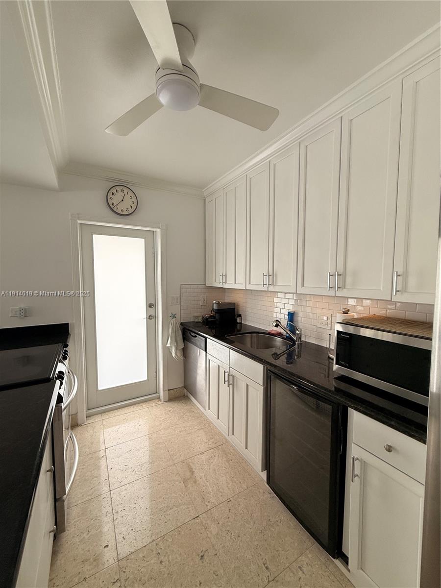 180 Isle Of Venice Drive, Unit 100 Fort Lauderdale, FL 33301 - Photo 6 of 16 a kitchen with granite countertop a sink dishwasher stove and white cabinets