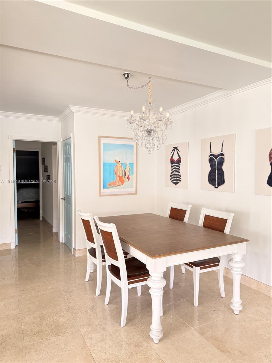 180 Isle Of Venice Drive, Unit 100 Fort Lauderdale, FL 33301 - Photo 7 of 16 a dining room with furniture and chandelier