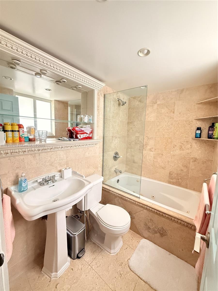 180 Isle Of Venice Drive, Unit 100 Fort Lauderdale, FL 33301 - Photo 10 of 16 a bathroom with a sink a toilet and bathtub