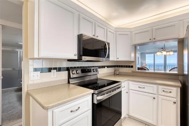 a kitchen with white cabinets and sink