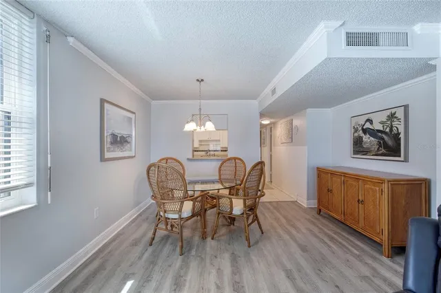 a dining room with furniture a chandelier and wooden floor