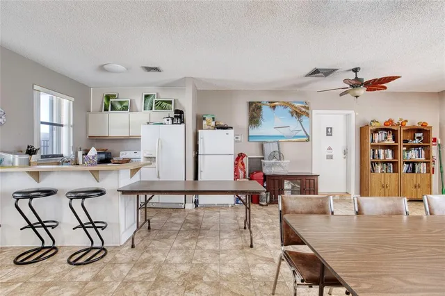 a view of a swimming pool with a yard and palm trees