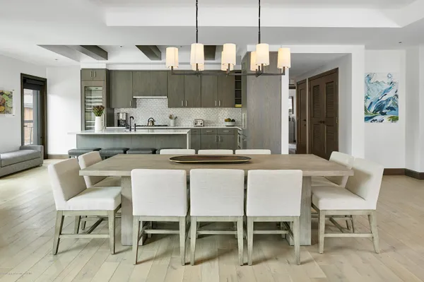 a kitchen with a dining table chairs and white cabinets