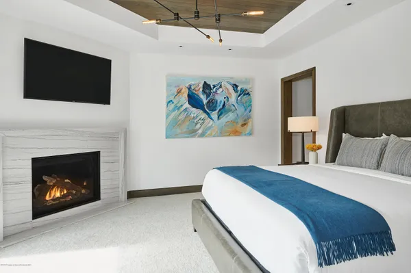 a spacious bedroom with a bed and a fireplace