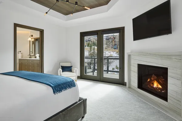 a spacious bedroom with a bed and a flat screen tv