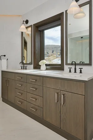 a bathroom with a double vanity sink and mirror with window