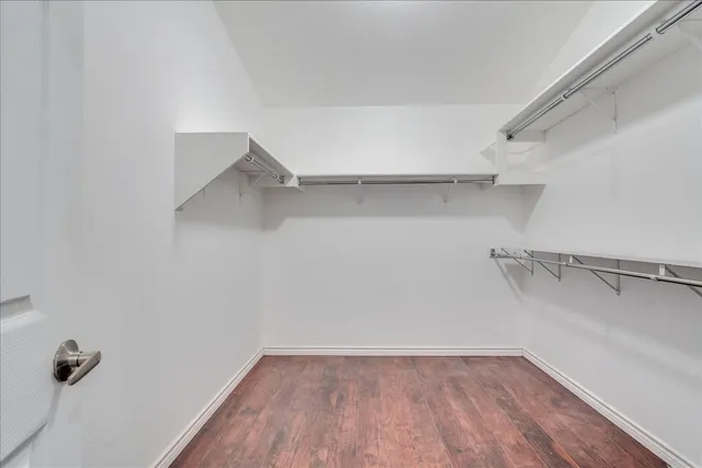 a view of walk in closet with empty racks