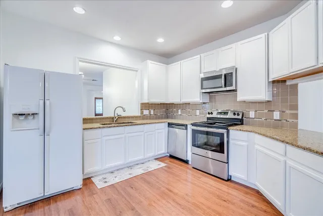 a kitchen with granite countertop white cabinets and white appliances