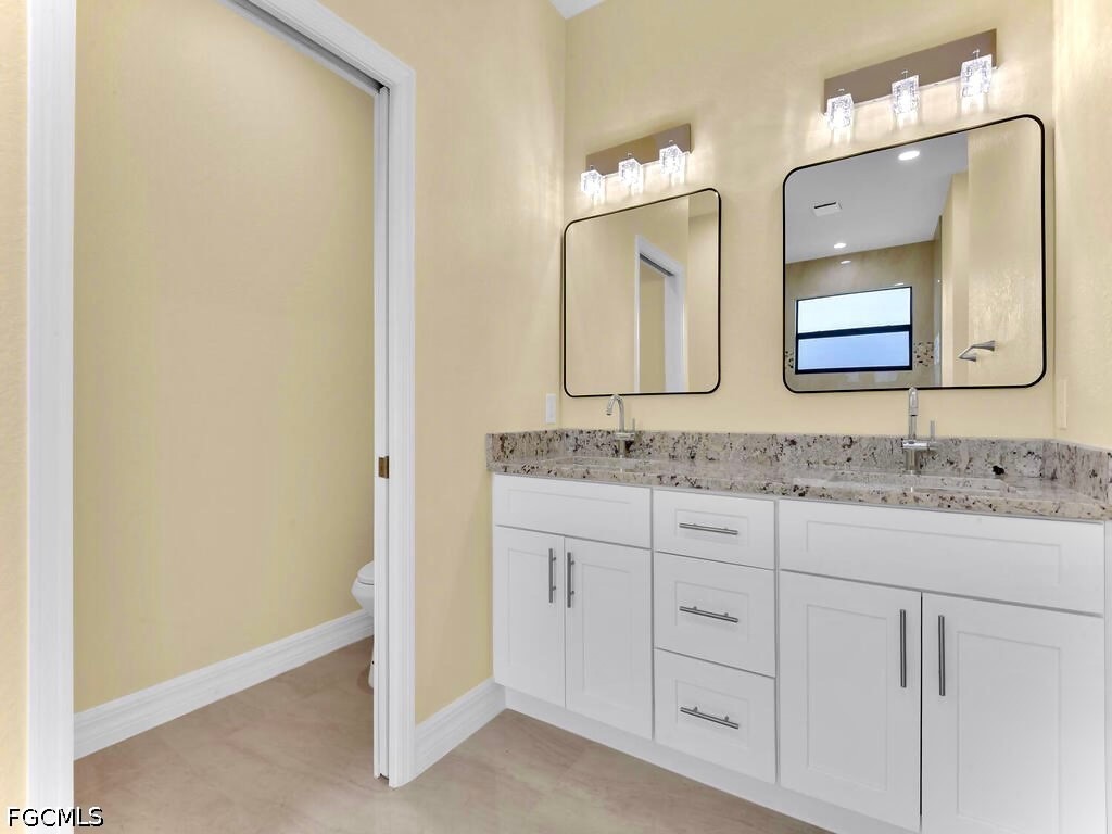 637 Cardinal Street East Lehigh Acres, FL 33974 - Photo 11 of 34 a bathroom with a granite countertop sink and a mirror