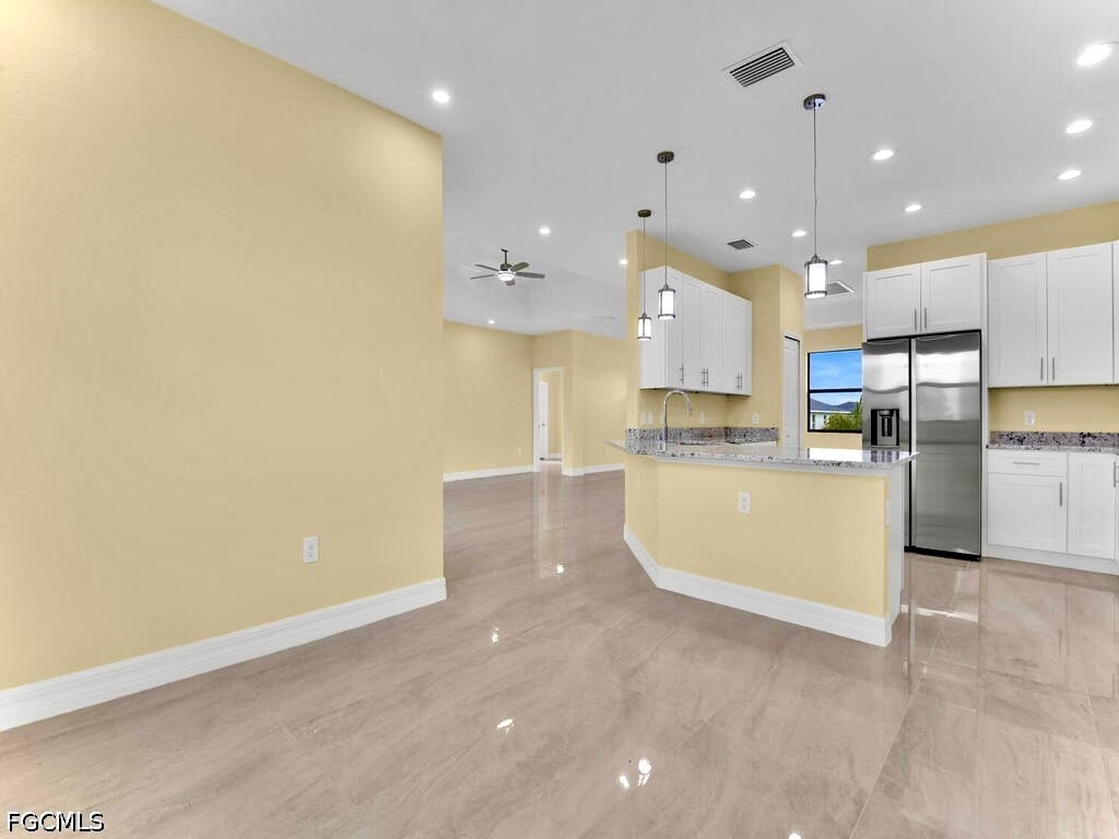 637 Cardinal Street East Lehigh Acres, FL 33974 - Photo 16 of 34 a large kitchen with stainless steel appliances a large counter top a oven and a refrigerator