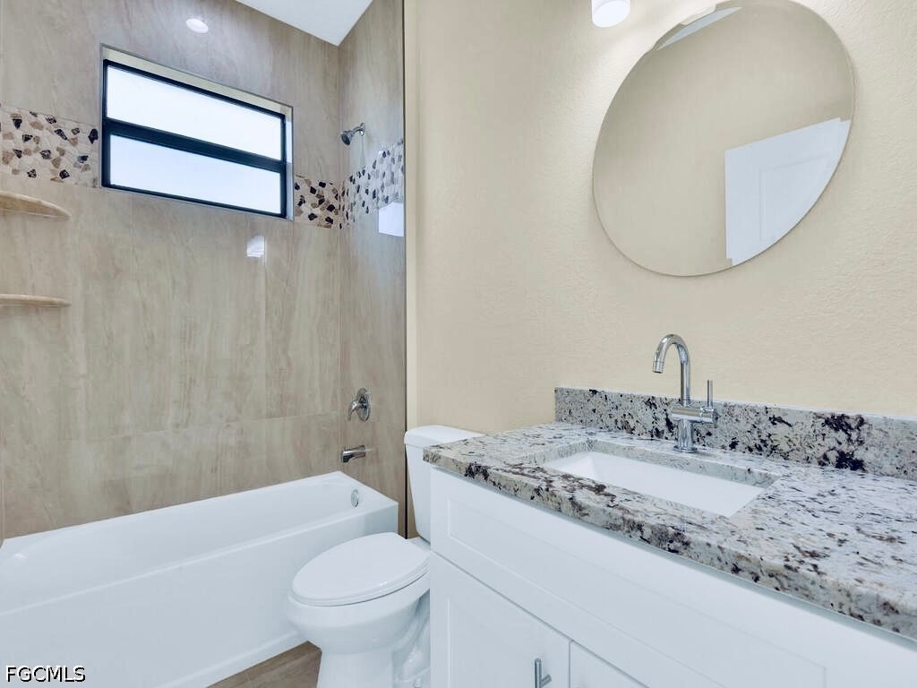 637 Cardinal Street East Lehigh Acres, FL 33974 - Photo 19 of 34 a bathroom with a sink a toilet and a mirror