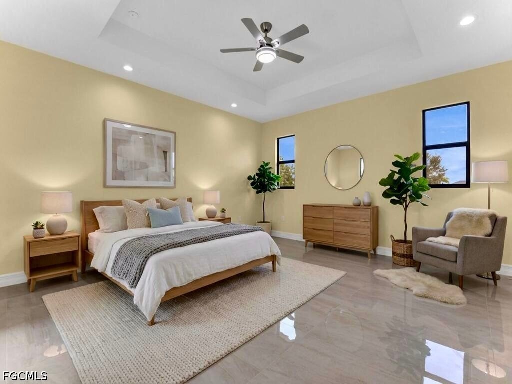 637 Cardinal Street East Lehigh Acres, FL 33974 - Photo 7 of 34 a spacious bedroom with a bed a chandelier and a chandelier