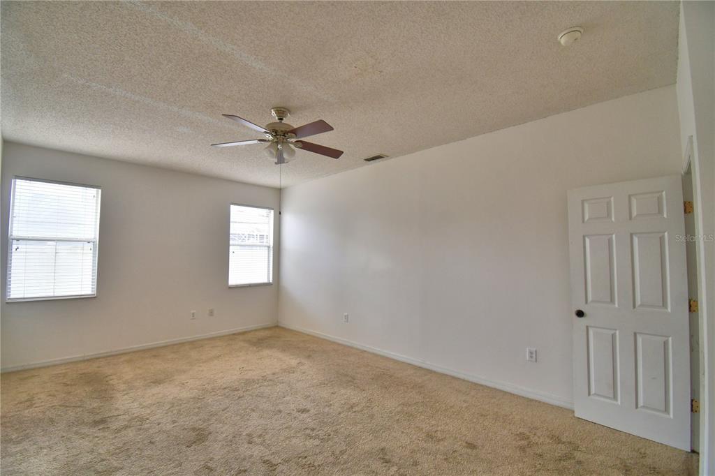 154 Canna Drive Davenport, FL 33897 - Photo 16 of 85 an empty room with a window and a ceiling fan
