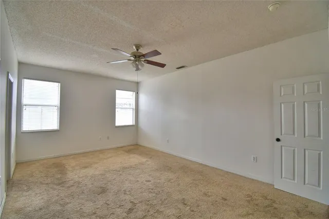 a kitchen with stainless steel appliances granite countertop a refrigerator a sink dishwasher a stove and white countertops with wooden floor