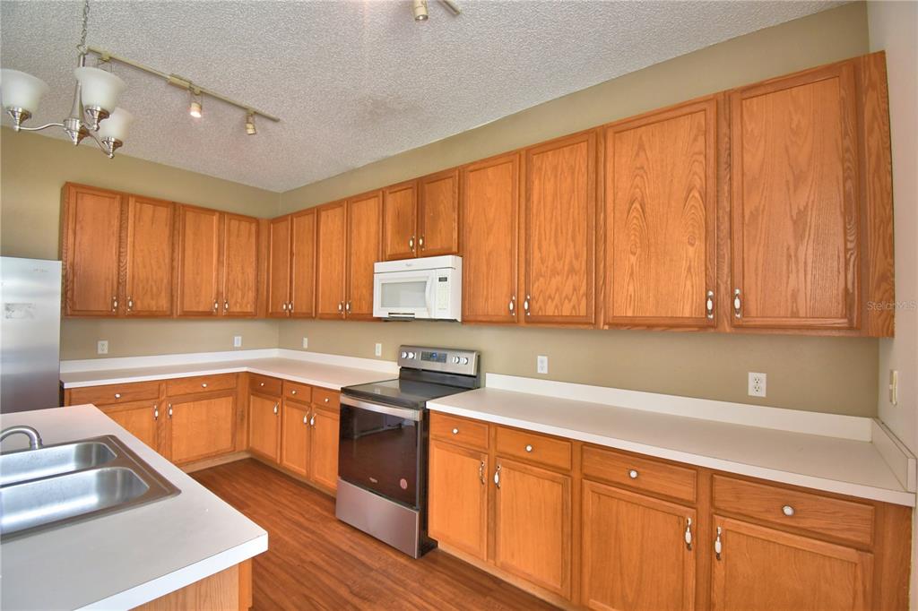154 Canna Drive Davenport, FL 33897 - Photo 29 of 85 a kitchen with stainless steel appliances granite countertop a sink stove and cabinets