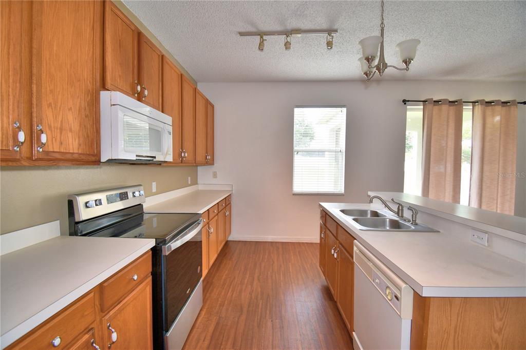154 Canna Drive Davenport, FL 33897 - Photo 30 of 85 a kitchen with stainless steel appliances granite countertop a sink stove and refrigerator