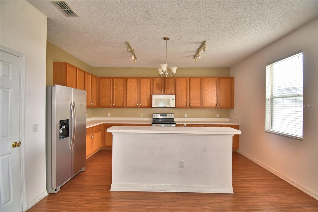 154 Canna Drive Davenport, FL 33897 - Photo 32 of 85 a kitchen with stainless steel appliances granite countertop a sink a stove and a refrigerator