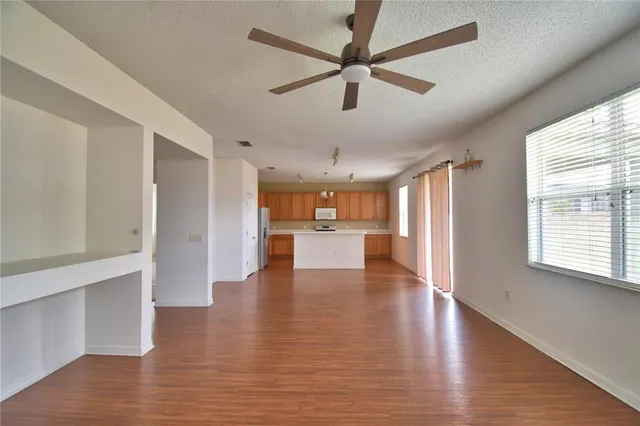 an empty room with windows and fan